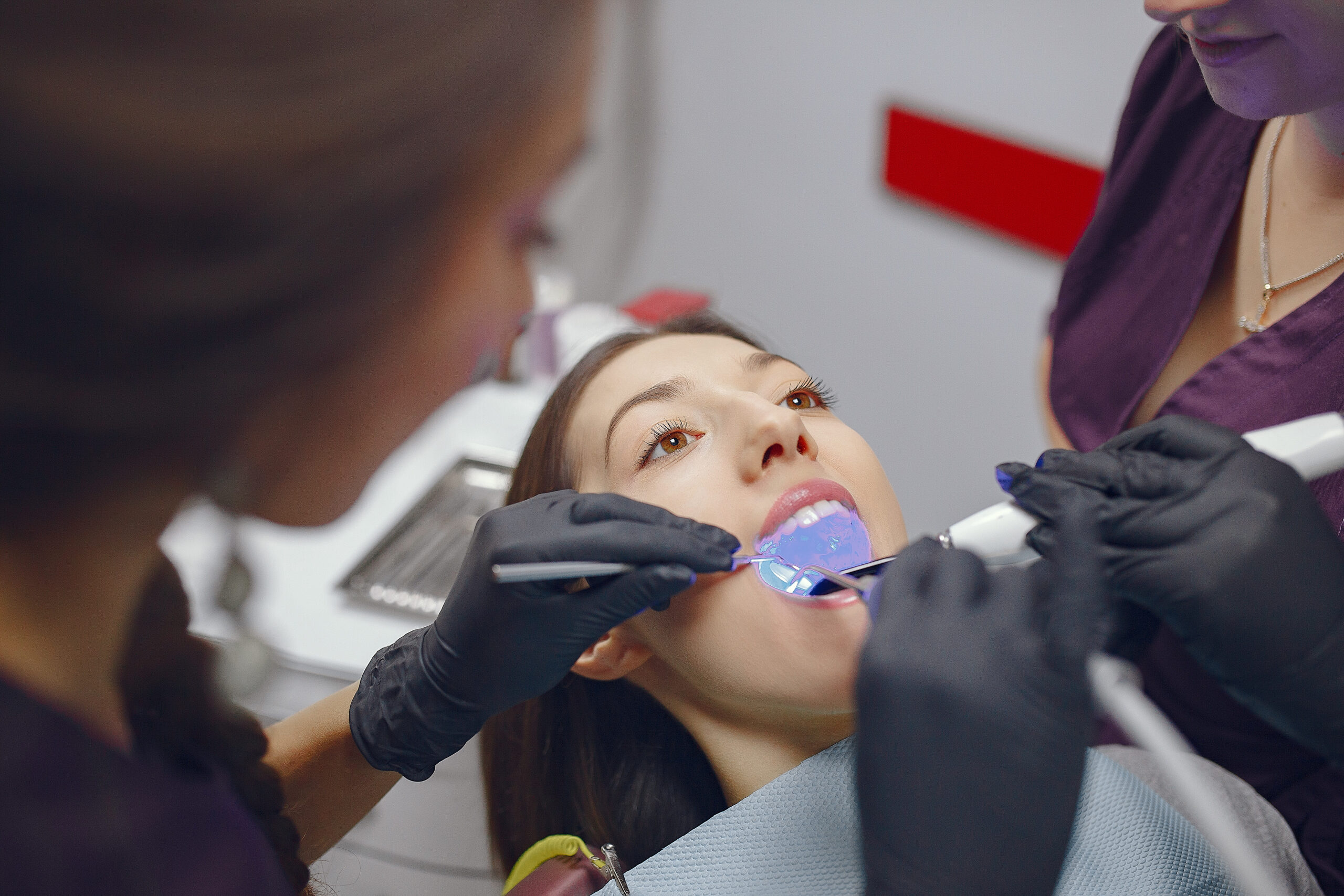Beautiful lady in the dentist's office. Woman in a purple uniform
